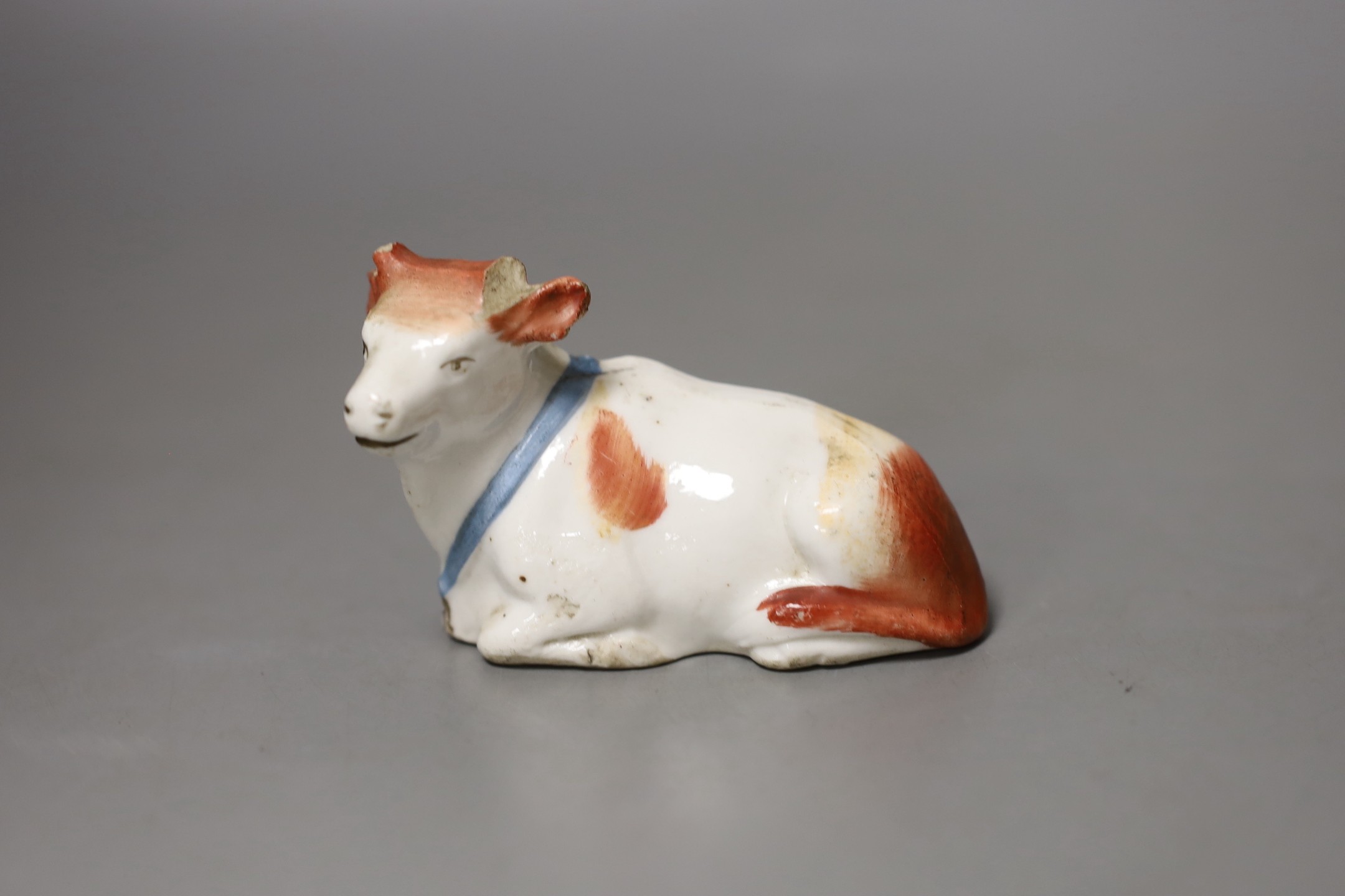 A group of Staffordshire animal and bird figures, to include a pair of sheep spill vases, two parrots, a swan spill vase, two further sheep and a cow and a continental pottery sheep tureen and cover - tallest 21.5cm